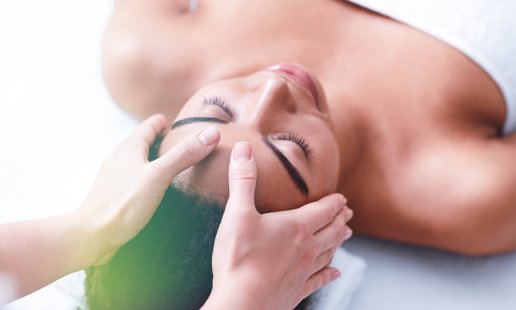 Massage therapist giving a scalp massage to a patient
