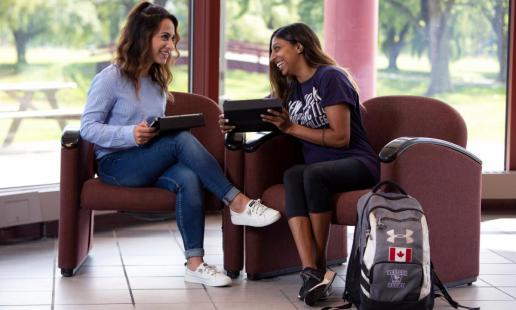 Northeast students laughing next to a backpack with a Canadian patch