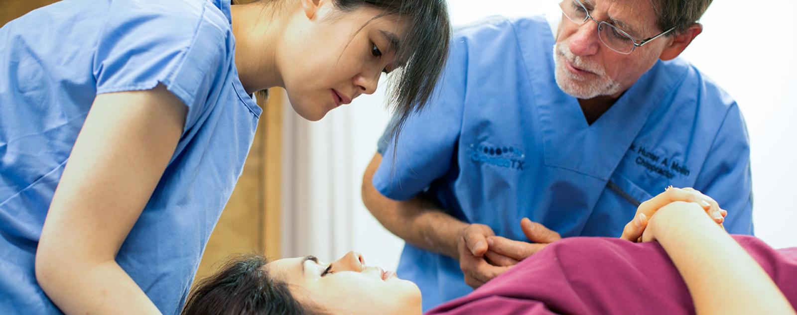 Student being instructed on how to perform a chiropractic adjustment
