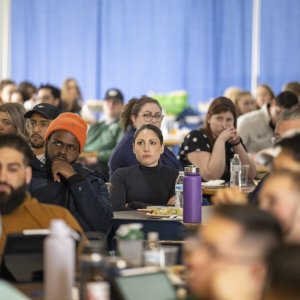 students seated at tables, listening intently