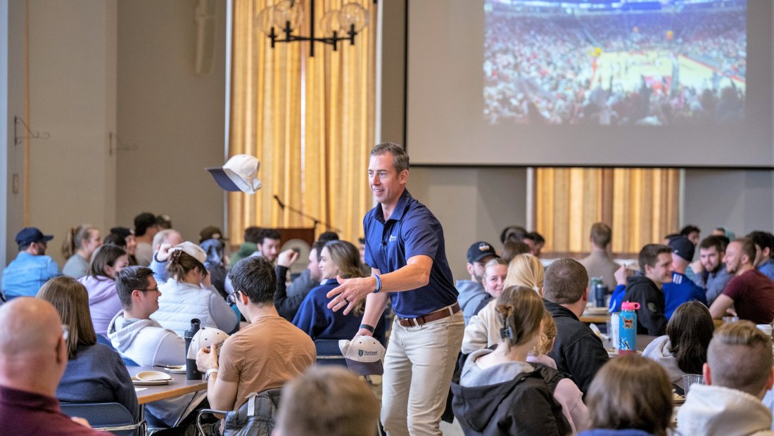 Dr. Kollmann tossing a hat to an audience member