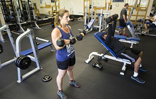 A group of people exercising using free weights