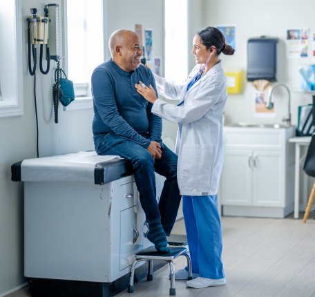 Physician assistant working with a patient sitting on a table