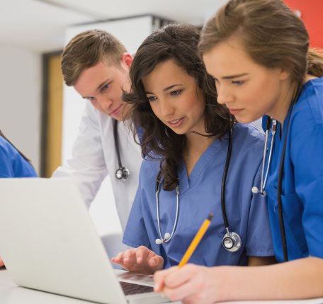 students gathered around a laptop