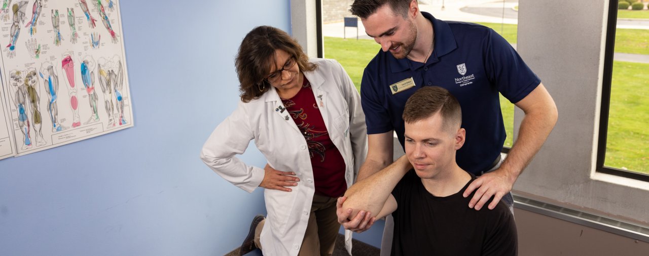 faculty member advising student practicing a chiropractic adjustment