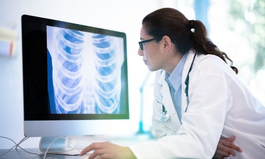 a radiologic technologist reviewing an X-ray