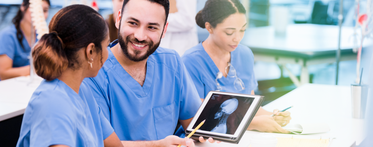A radiologic technologist showing a medical team member an X-Ray on a tablet